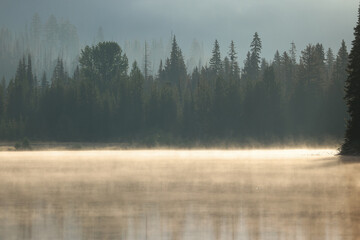 the steaming lightning lake in British Columbia in the early morning sunlight