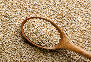 Quinoa grains in a wooden spoon background. Top view