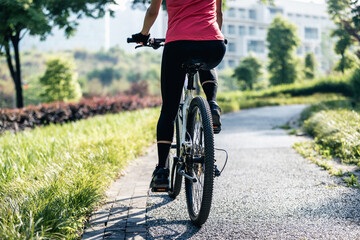 Naklejka premium Woman riding mountain biking in sunny park