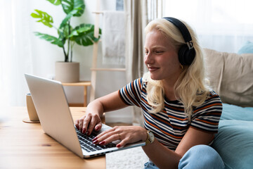 Young introvert freelancer businesswoman with ADHD working remotely from home office on laptop...