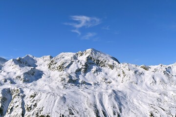 Obraz premium Breathtaking view of snowcapped mountain peaks against a blue sky in Ötztal Valley, Tyrol, Austria. Shot during peak ski season in the winter.