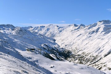 Beautiful view of the snowy &Ouml;tztal Valley, Tyrol, Austria during peak ski season in the winter. Chair lifts and pistes in Hochgurgl ski resort on a beautiful sunny day.