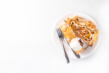 Sweet homemade pumpkin strudel. Tasty autumn pumpkin squash strudel cake with walnut and cinnamon, topped with vanilla ice cream scoop
