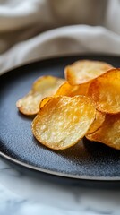 Crispy potato chips with fresh dill garnish on a black plate, close-up.