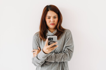 Fototapeta premium Asian Thai woman wear sweater, holding and using mobile phone with doubt face, communication problem.