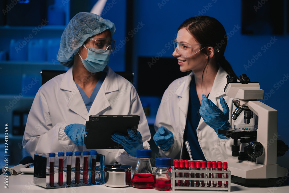 Wall mural team of biochemical research scientists working with a microscope for vaccine development