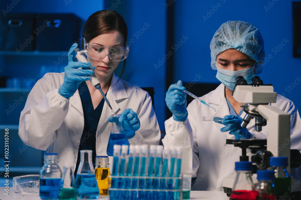 Wall mural team of biochemical research scientists working with a microscope for vaccine development
