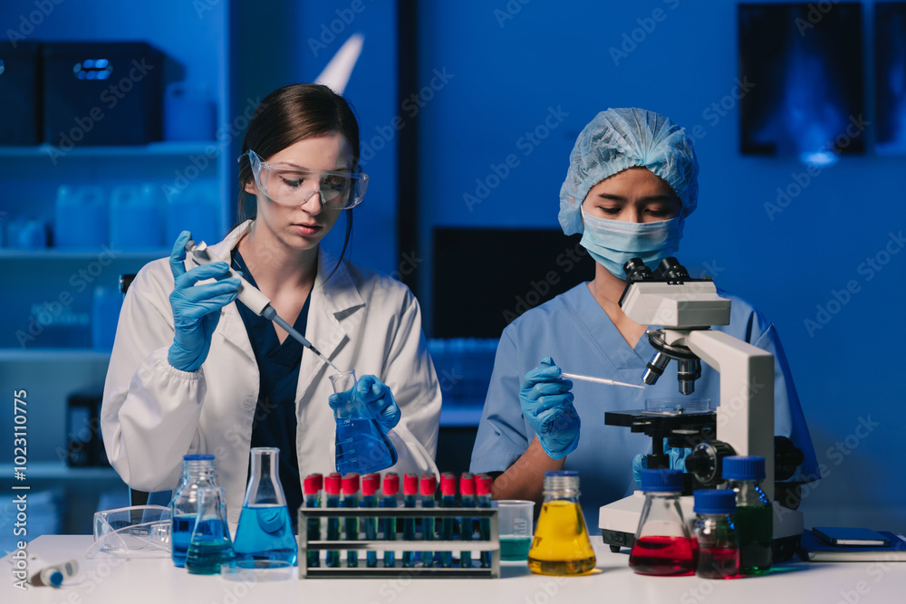 Wall mural team of biochemical research scientists working with a microscope for vaccine development