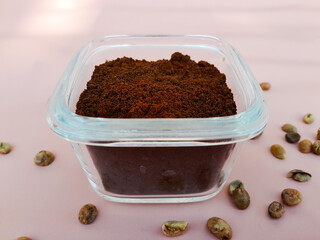 Coffee powder in a glass bowl and sprinkled with coffee beans