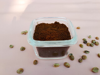 Coffee powder in a glass bowl and sprinkled with coffee beans