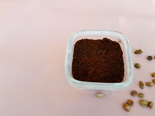 Coffee powder in a glass bowl and sprinkled with coffee beans
