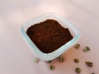 Coffee powder in a glass bowl and sprinkled with coffee beans