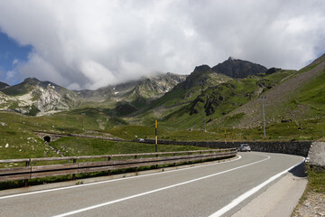 View of the road and surrounding mountain landscape at Colle del Gran San Bernardo in Saint-Rhémy-en-Bosses, Aosta Valley, Italy. The high altitude road crosses the border from Italy into Switzerland.