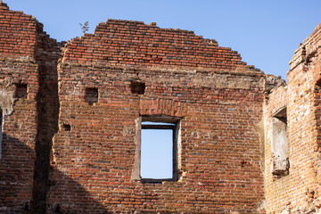 Interior of an old brick building, trees visible outside