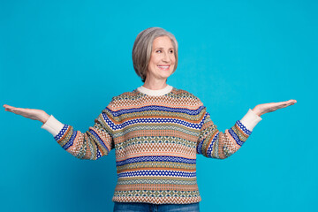 Portrait of positive person with bob hairdo wear pullover arms presenting objects look empty space isolated on blue color background