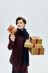 A fashionable woman dressed elegantly for winter smiles, cradling a gift as others await her touch.