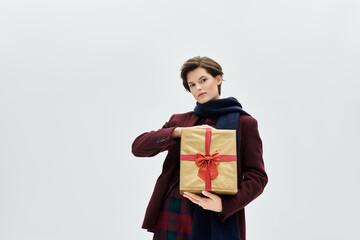 In cozy winter wear, a woman holds a gift with a festive bow, exuding charm and elegance.