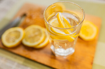 Close up of a lemon slices and a glass of water. Healthy food or drink concept.