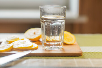 Close up of a lemon slices and a glass of water. Healthy food or drink concept.