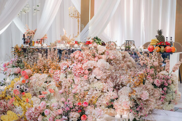 Elegant interior decor with white seating, golden candelabras, and floral arrangements