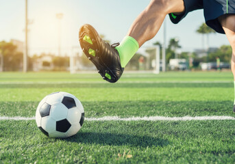 Obraz premium Soccer player wearing cleats is kicking a soccer ball on a field during a match
