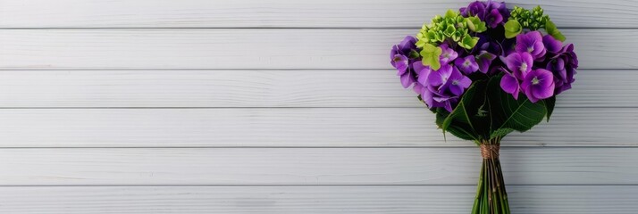 Purple flower bouquet on white wood background.
