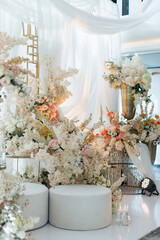 Elegant interior decor with white seating, golden candelabras, and floral arrangements