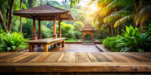 Wooden table with a view of a tropical garden with a gazebo and palm trees