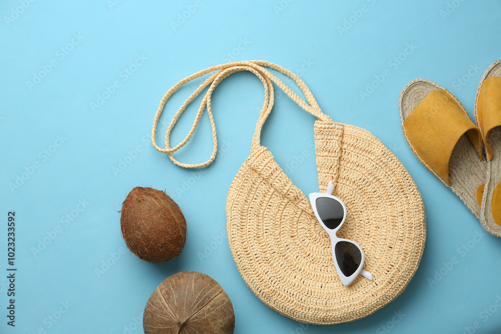 Poster Flat lay composition with woman's straw bag on light blue background