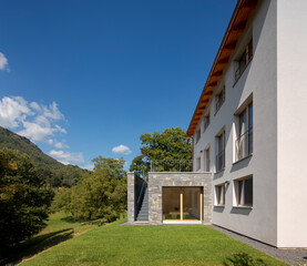 Front view of a newly finished house with bedroom with direct access to the garden. To the left of the room, there is an external staircase. Nobody inside