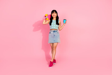 Photo of cheerful positive girl wear trendy clothes hold penny board isolated on pink color background