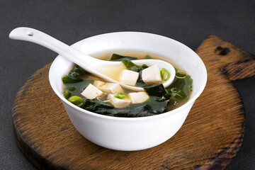 Seaweed soup with tofu on wooden board.