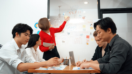 Young beautiful leader presents marketing strategy while expert investor and project manager listening and lecturing to analyze business performance at start up business meeting. Immaculate.