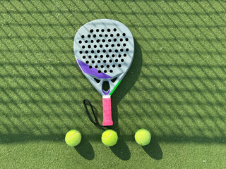 paddle tennis racket and balls on court 