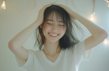 Fototapeta premium A Young Woman with Long Dark Hair Smiles and Holds Her Hair Up