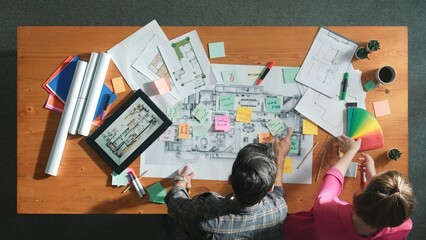 Top view of engineer working together to design building construction while standing at meeting table with blueprint and notes. Top view of interior designer choosing color from palettes. Symposium.