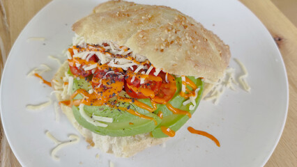Sandwich frisch gebacken, gefüllt mit Tomate, Avocado und Käse