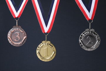 Golden, silver and bronze medals on dark grey background