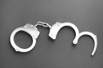 Classic chain handcuffs on black background, top view