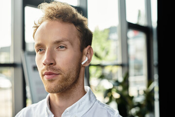 A redheaded professional immersed in work, collaborating on a project in a contemporary office environment.