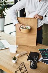 A man with red hair in a white shirt is taking a break to enjoy his lunch in a stylish office.