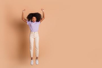 Full length portrait of pretty young woman jump fall empty space wear t-shirt isolated on beige...