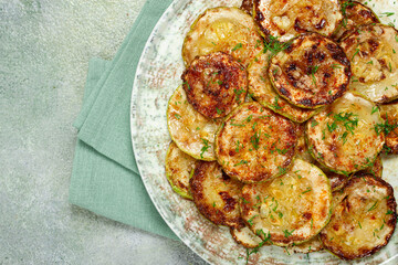fried zucchini, cut into rings, with garlic and herbs, on a plate, top view, homemade, no people,