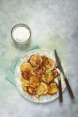 fried zucchini, cut into rings, with garlic and herbs, on a plate, top view, homemade, no people,
