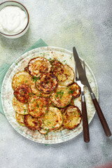 fried zucchini, cut into rings, with garlic and herbs, on a plate, top view, homemade, no people,