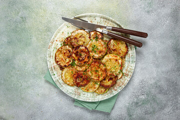 fried zucchini, cut into rings, with garlic and herbs, on a plate, top view, homemade, no people,