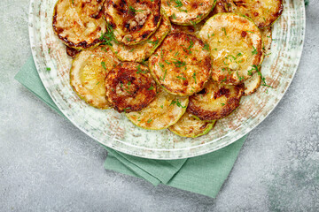 fried zucchini, cut into rings, with garlic and herbs, on a plate, top view, homemade, no people,