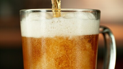 Close-up of beer pouring into pint , freeze motion.