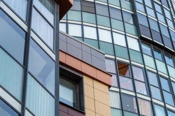A tall building with many windows. The building has a modern look and he is a commercial or office building