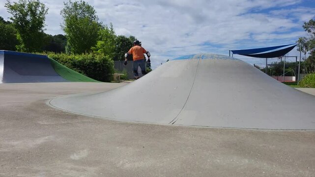 Ein Mann, der mit Inlineskates auf einer Halfpipe in einem Skatepark f&auml;hrt. 